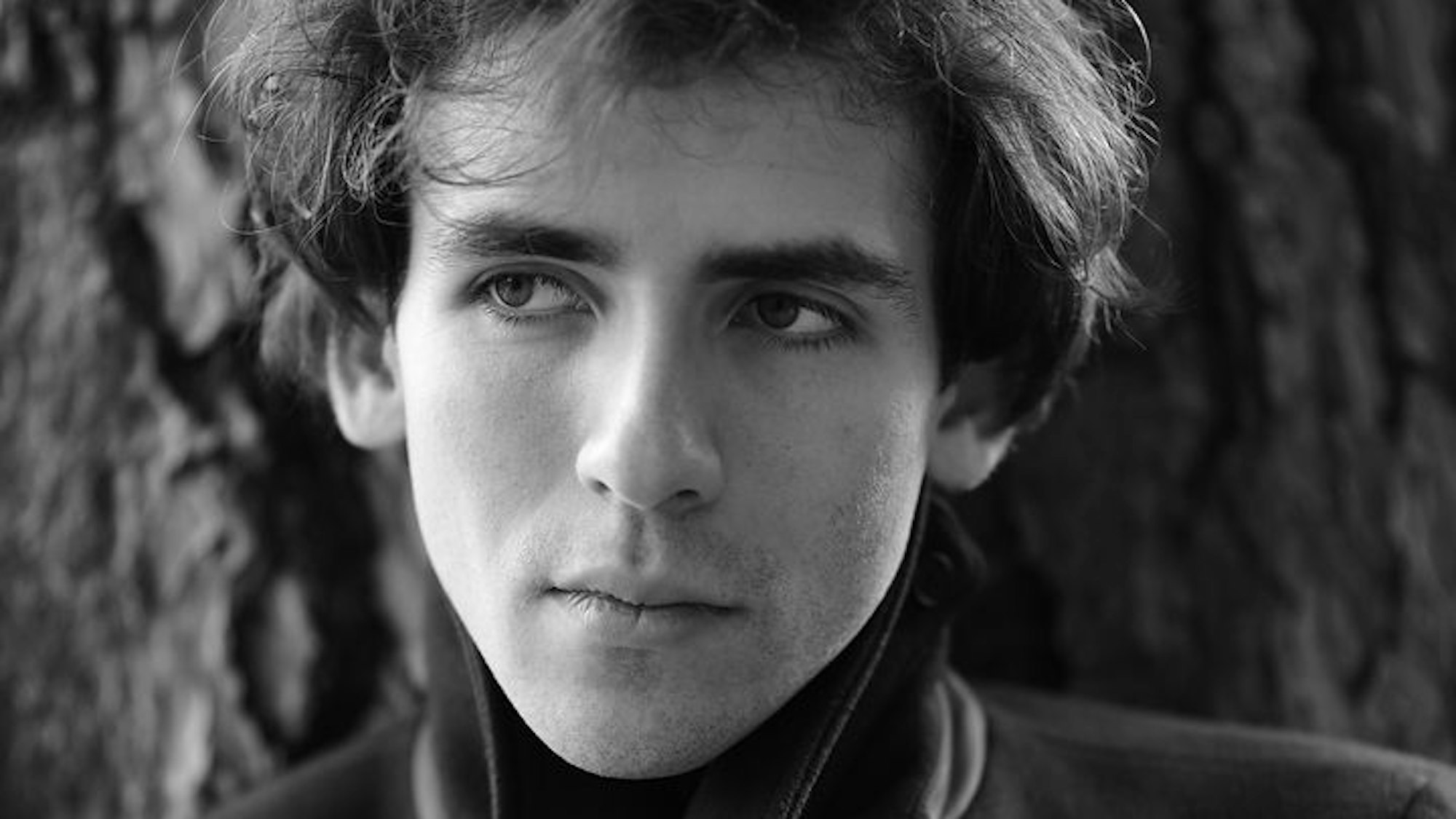 Das Bild zeigt Alexandre Kantorow in schwarz-weiß. Der junge Künstler hat dunkle Haare und schaut ernst.