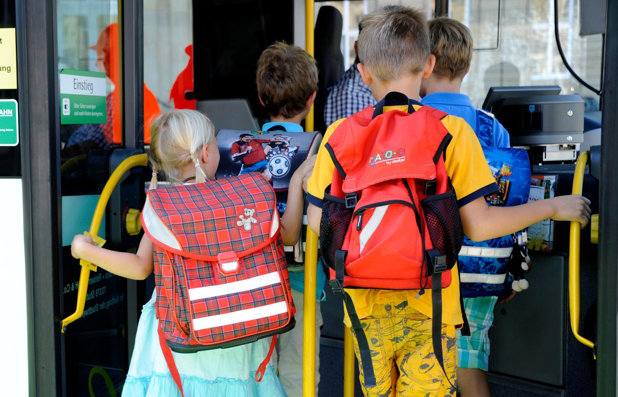 Kinder steigen in einen Schulbus ein