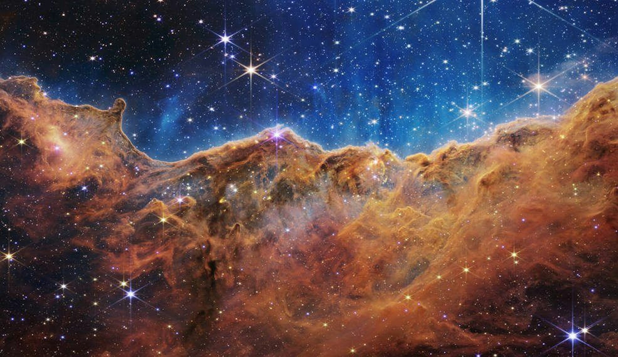 HANDOUT - 12.07.2022, ---: Das von der US-amerikanischen Weltraumbehörde NASA zur Verfügung gestellte Bild zeigt einen Blick auf den Carina-Nebel (Carina Nebula). Diese mit "Landschaft" ist der Rand einer nahe gelegenen, jungen Sternentstehungsregion namens NGC 3324 im Carina-Nebel. Dieses Bild, das vom neuen James-Webb-Weltraumteleskop der NASA im Infrarotbereich aufgenommen wurde, zeigt zum ersten Mal zuvor unsichtbare Bereiche der Sternentstehung. Foto: NASA, ESA, CSA, and STScI/dpa - ACHTUNG: Nur zur redaktionellen Verwendung und nur mit vollständiger Nennung des vorstehenden Credits +++ dpa-Bildfunk +++