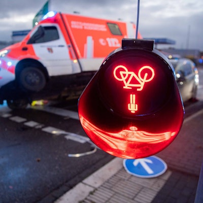 Das Bild zeigt einen Unfall in Kommern. Im Hintergrund ist ein Rettungswagen verunglückt, im Vordergrund hängt eine zerstörte Fußgängerampel herab.
