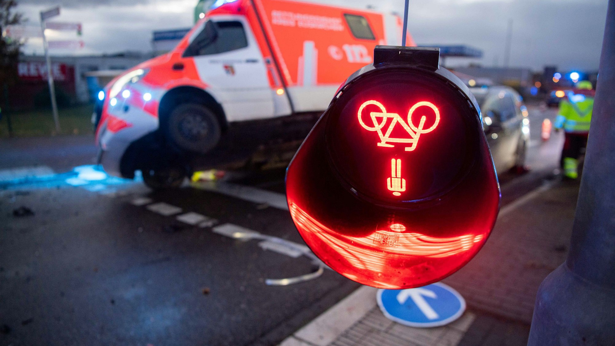 Das Bild zeigt eine herunterhängende Fußgängerampel. Im Hintergrund ist der verunfallte RTW zu sehen.