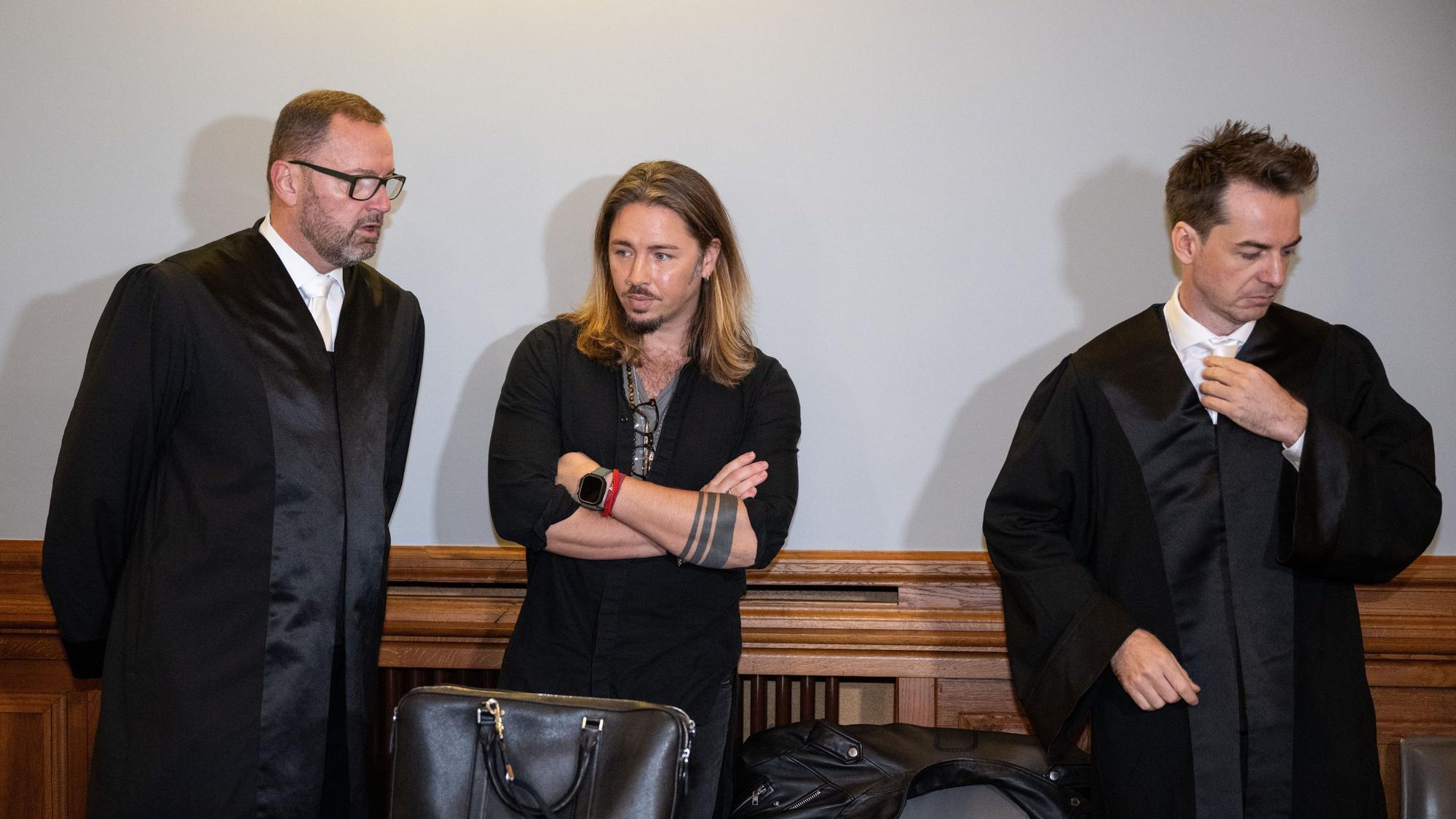 Der deutsche Rockmusiker Gil Ofarim (M) steht im Saal des Landgerichts in Leipzig zwischen seinen Anwälten.