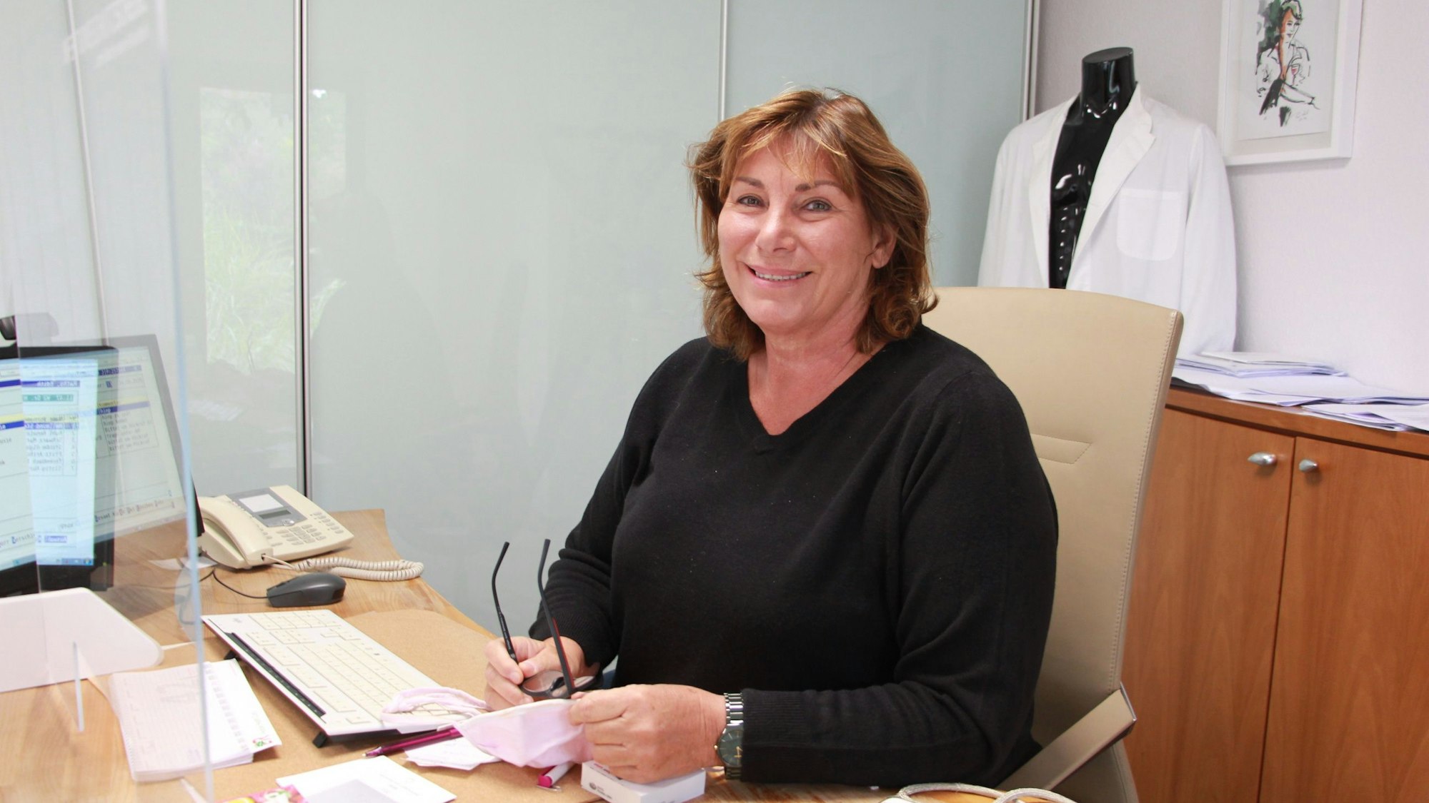 Eine Ärztin sitzt am Schreibtisch.