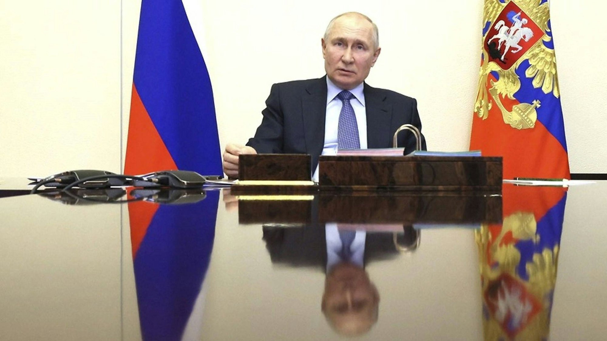 Der russische Präsident Wladimir Putin spiegelt sich in einer Tischplatte. Der ukrainische Geheimdienst spricht von „zuverlässigen Informationen“ über Doppelgänger des Kremlchefs. (Archivbild)