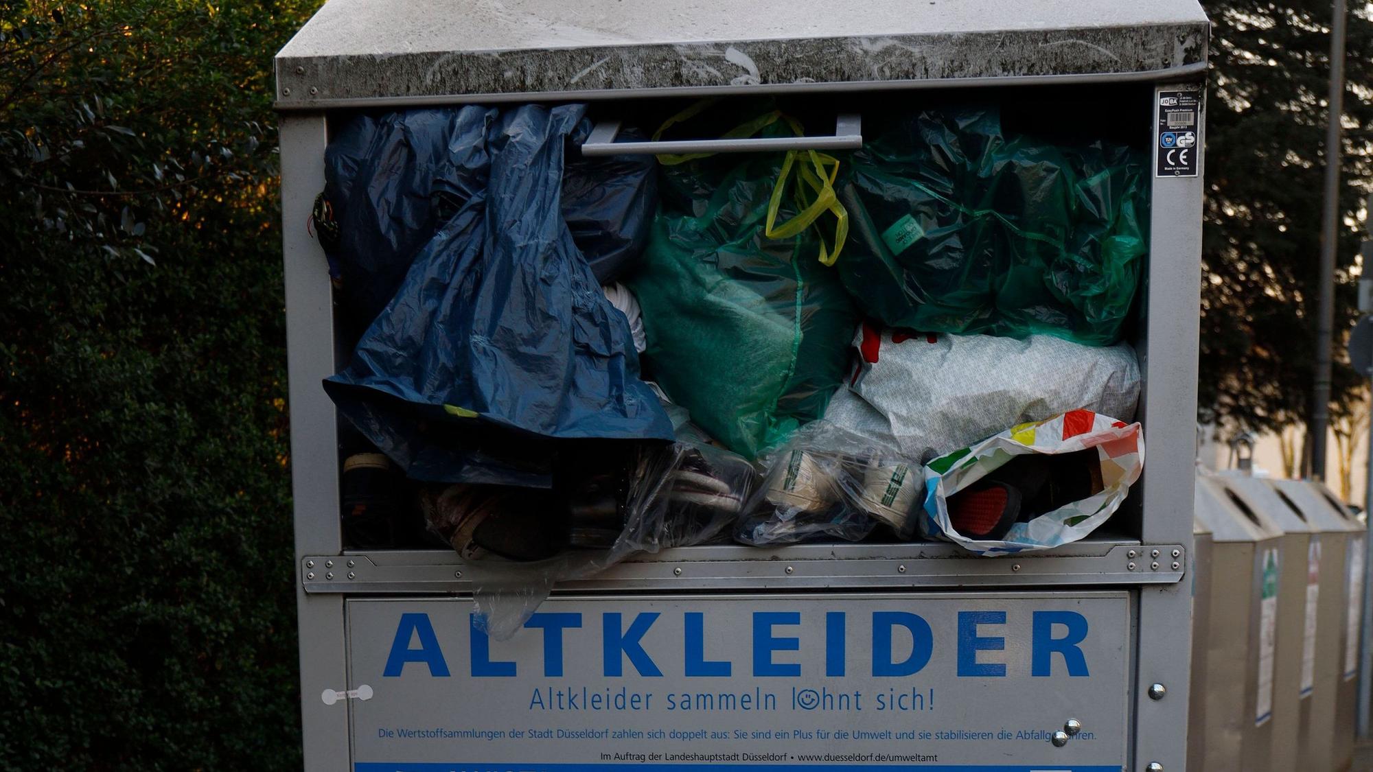 Container für Altkleider steht auf einem Bürgersteig in Düsseldorf