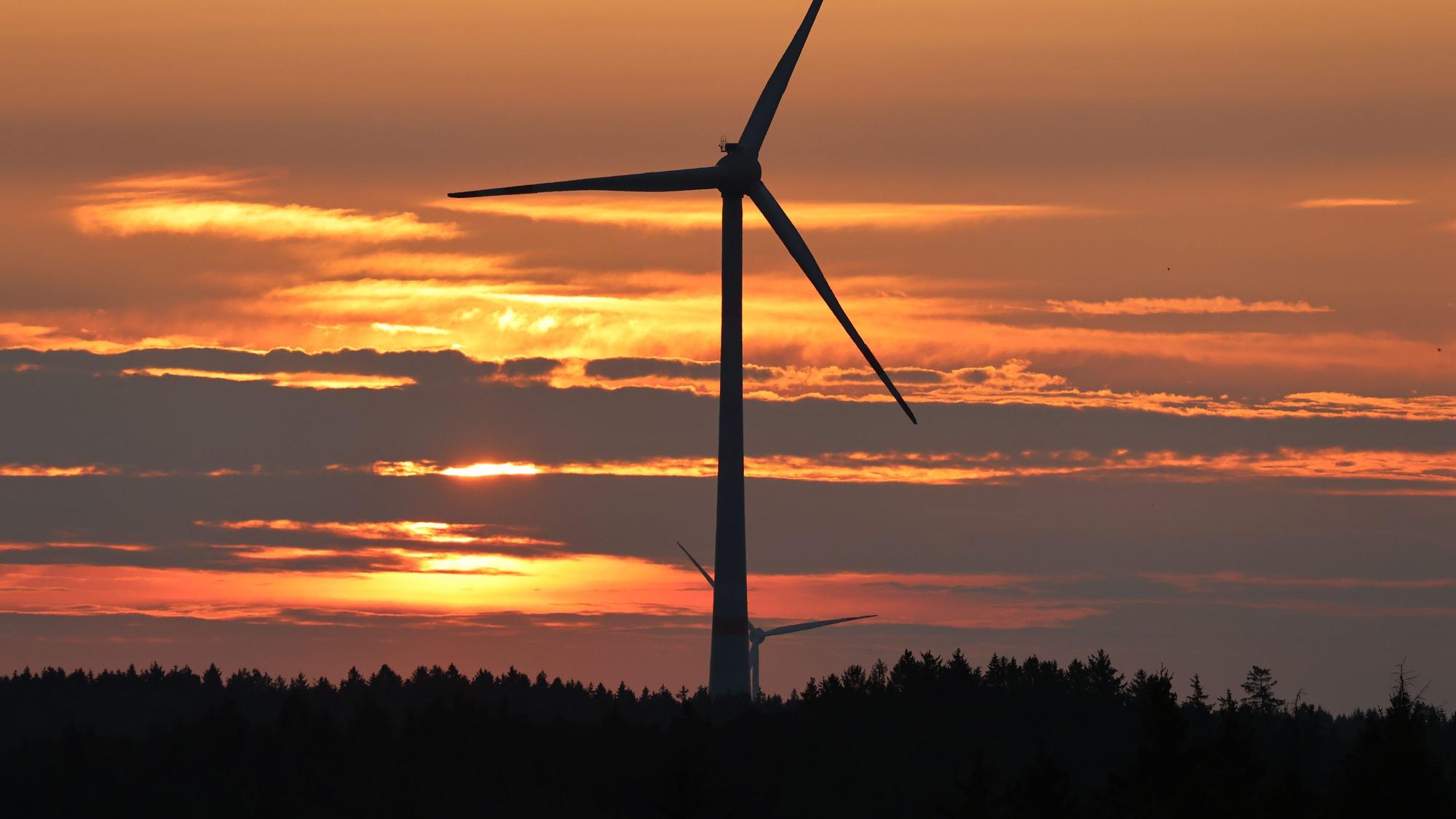 Das Bild zeigt ein Windrad in einem Wald auf dem Gebiet der Gemeinde Dahlem in der Abenddämmerung.