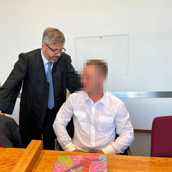 Ein Mann sitzt auf der Anklagebank. Neben ihm steht sein Anwalt.