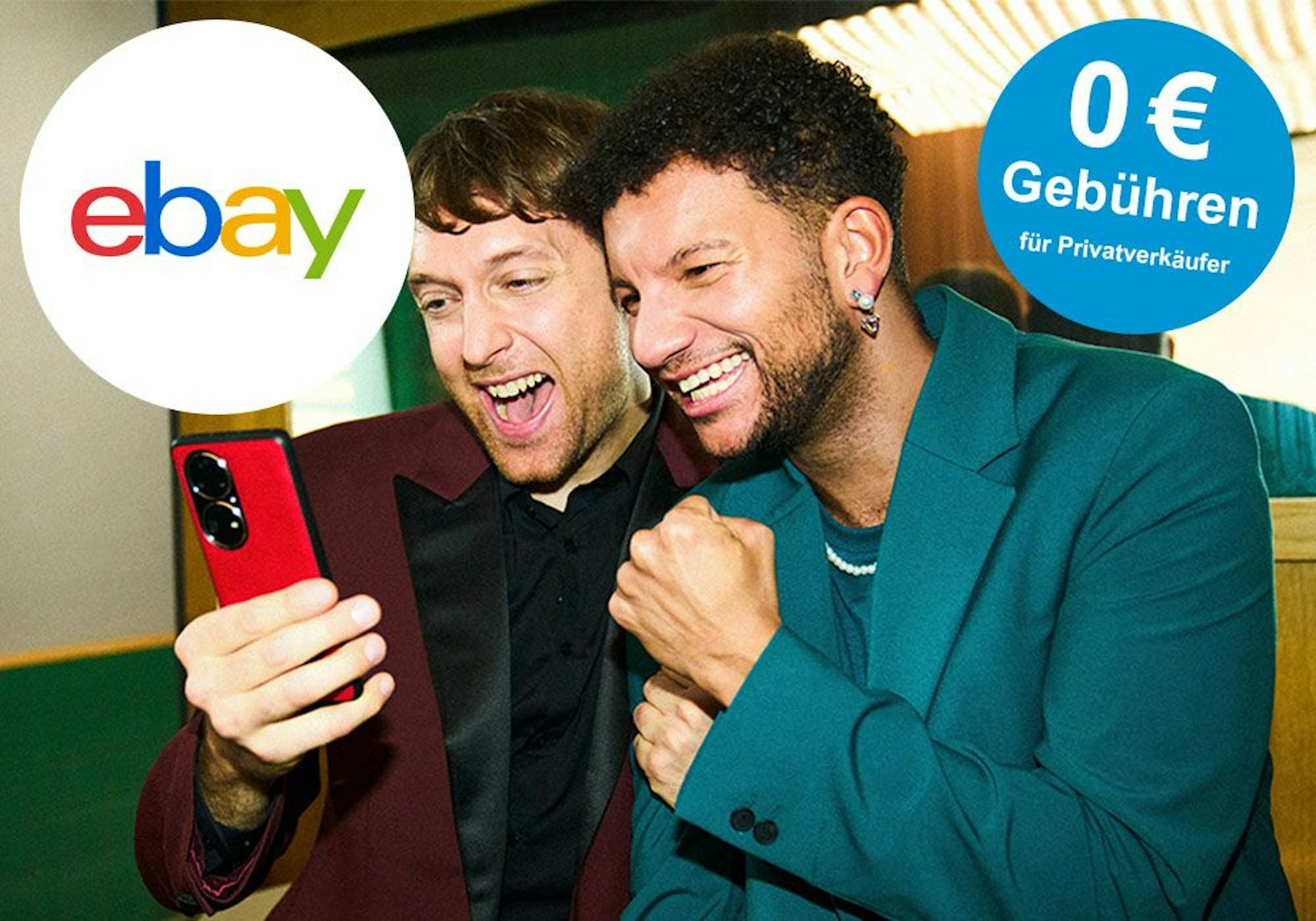 Zwei Männer schauen erfreut auf ein Handy.