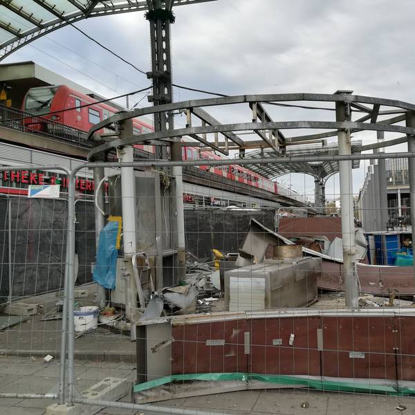 Trümmer der Currywurstbude hinter einem Bauzaun am Breslauer Platz.