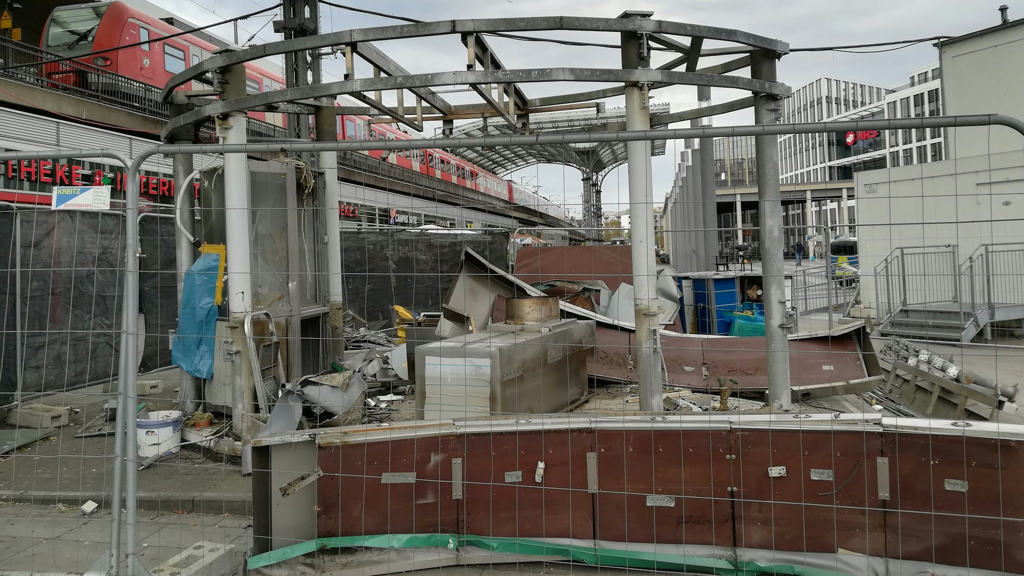 Trümmer der Currywurstbude hinter einem Bauzaun am Breslauer Platz.