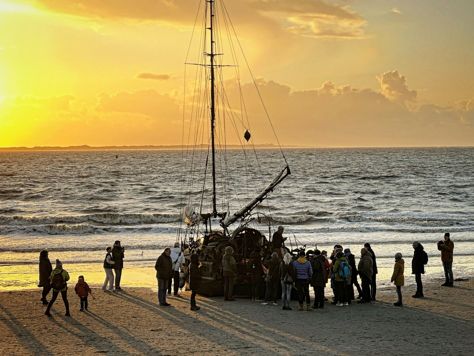 Ein am Weststrand der Insel Norderney gestrandetes Segelschiff mit Schaulustigen (undatierte Aufnahme).