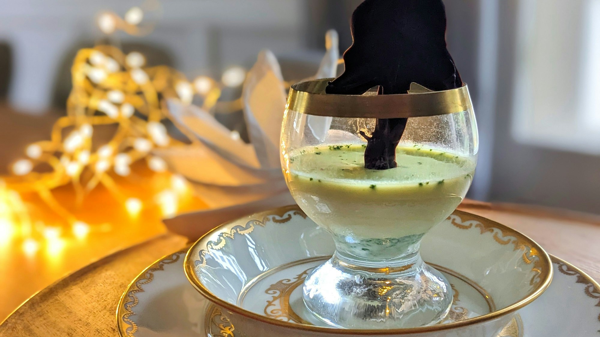 ILLUSTRATION - Der Tannenbaum aus geschmolzener Schokolade wird auf Backpapier selbst „gemalt“ und krönt die Basilikum Panna Cotta an Heiligabend.