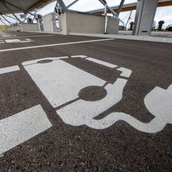 Vor einem Ladepunkt in einem Ladepark ist ein Symbol für ein E-Auto aufgemalt