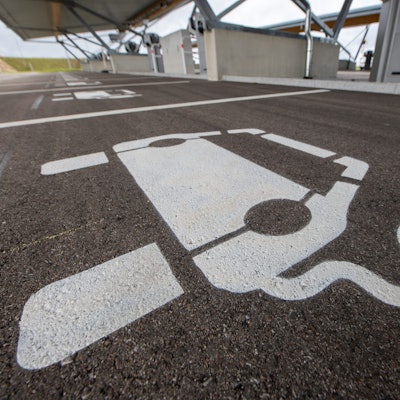 Vor einem Ladepunkt in einem Ladepark ist ein Symbol für ein E-Auto aufgemalt