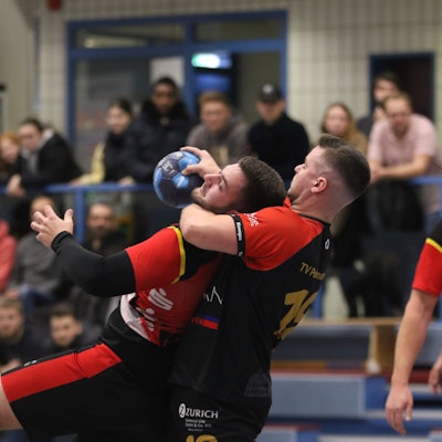 Ein Palmersheimer Handballer umschließt den Gegenspieler aus Bad Münstereifel am Hals.