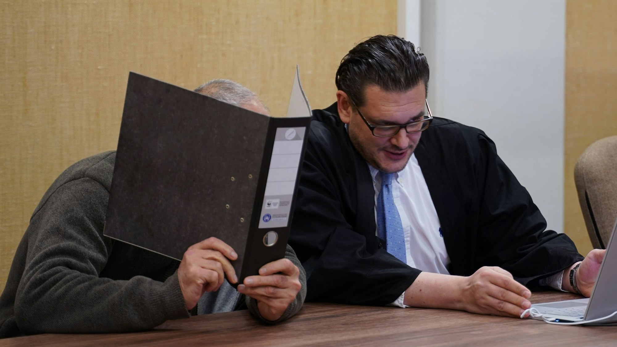 Der Angeklagte im Leverkusener Kiosk-Totschlag bespricht sich beim zweiten Verhandlungstag mit seinem Verteidiger.