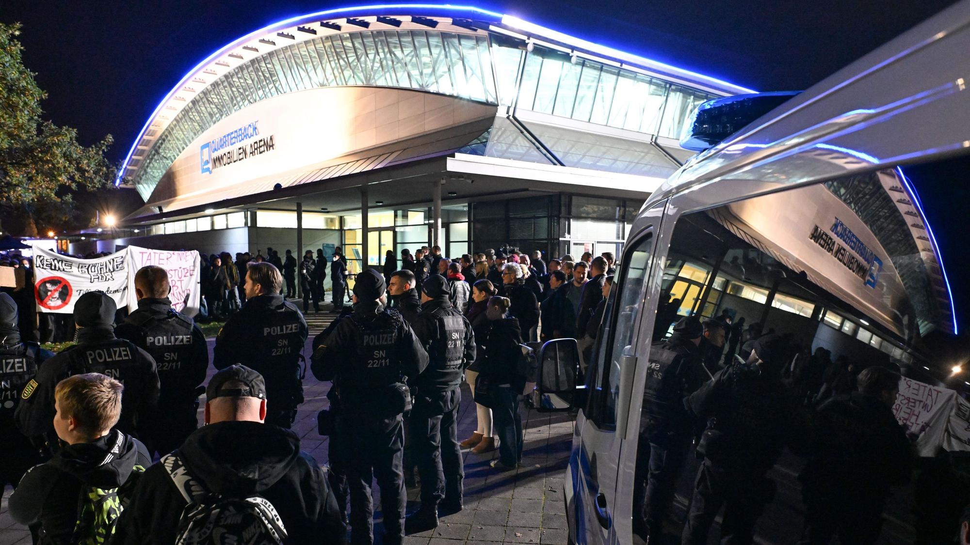 Solo-Konzert von Till Lindemann in Leipzig: Polizisten blicken auf den Gegenprotest, der sich gegen den Rammstein-Sänger stellt.