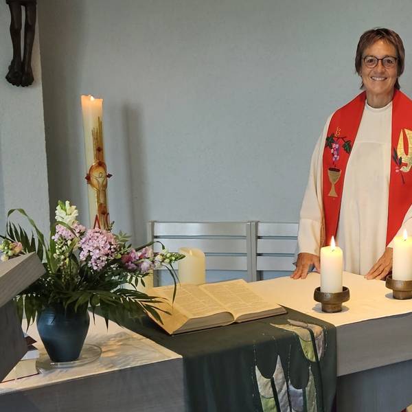 Krankenhausseelsorgerin Pfarrerin Gabriele Bach steht in Talar mit Stola an einem Altar.
