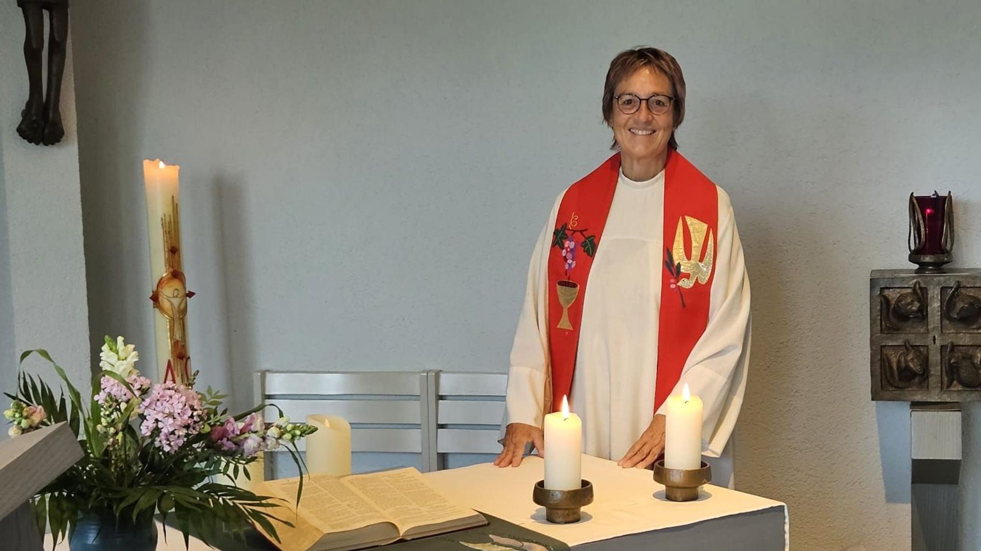 Krankenhausseelsorgerin Pfarrerin Gabriele Bach steht in Talar mit Stola an einem Altar.