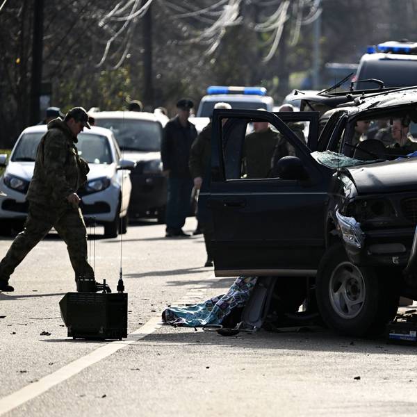 Einsatzkräfte stehen hinter einem ramponierten LKW.