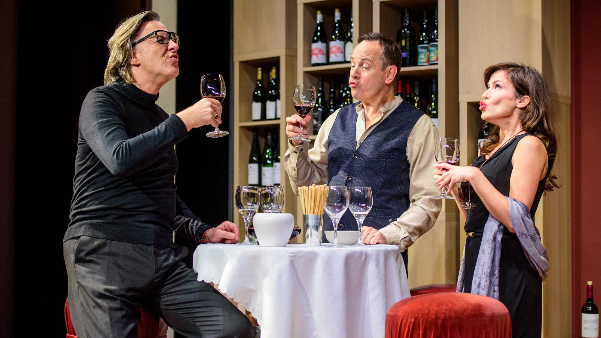 Martin Armknecht (l.), Moritz Lindbergh (m.) und Natalia Avelon (r.) verköstigen Wein in einer Szene des Theaterstücks „Weinprobe für Anfänger“.