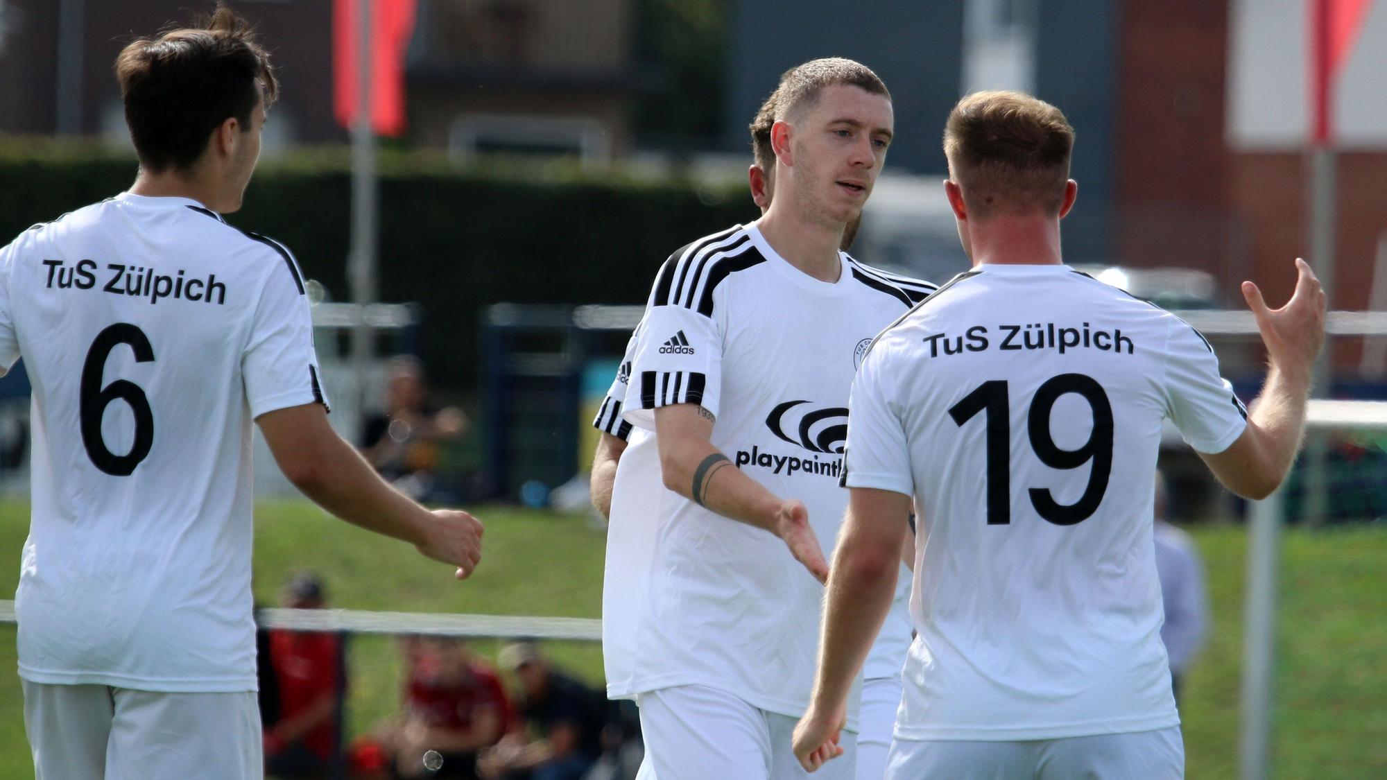 Zülpichs Dominik Spies (Mitte) klatscht mit seinen Mitspielern nach einem Tor ab.