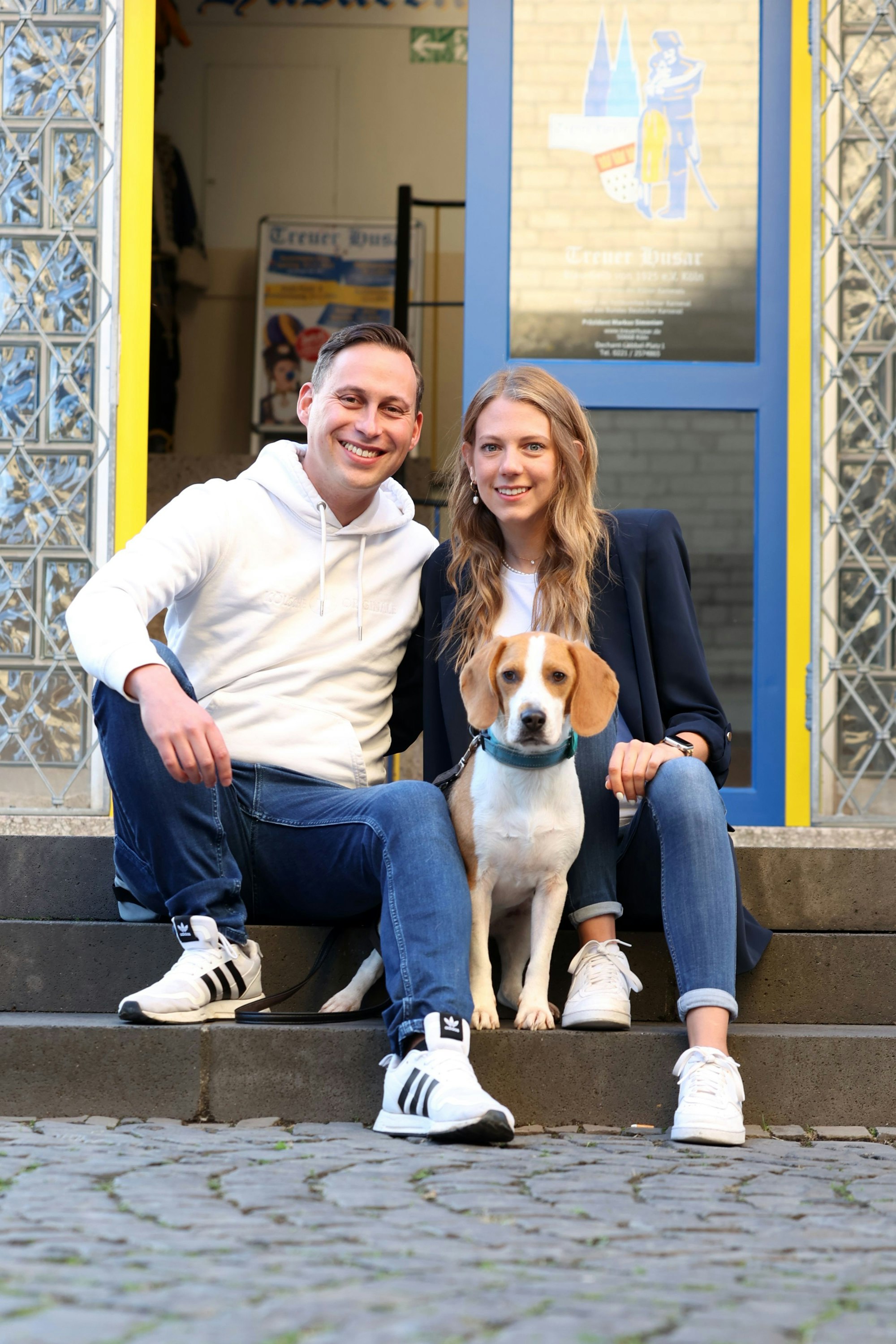 Sascha Klupsch sitzt mit seiner Freundin Corinna und Hund Charlie auf einer Treppe.