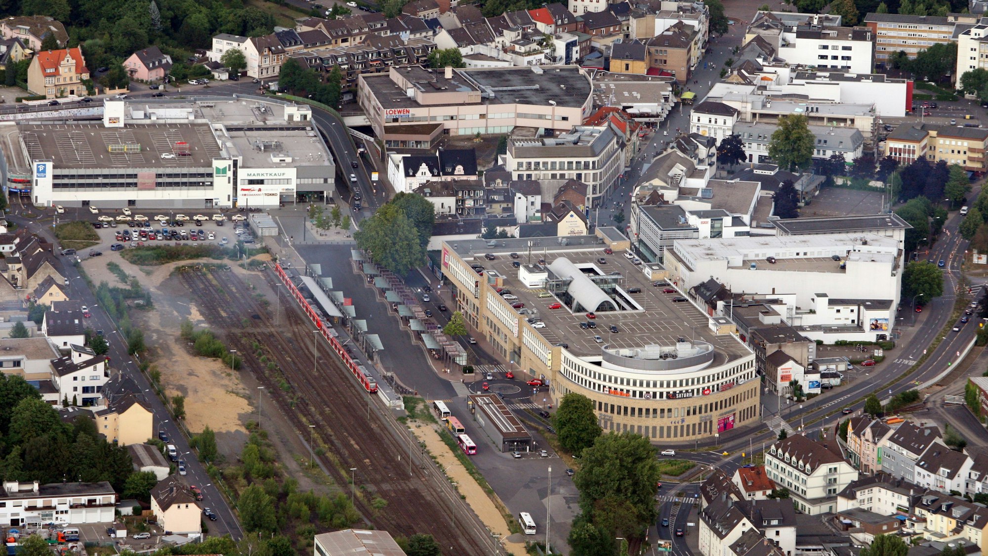 Auf dem Luftbild ist das Geschäftshaus Rheinberg-Passage mit Parkhaus zu sehen. Die S-Bahn-Gleise grenzen unmittelbar an die Immobilie an.