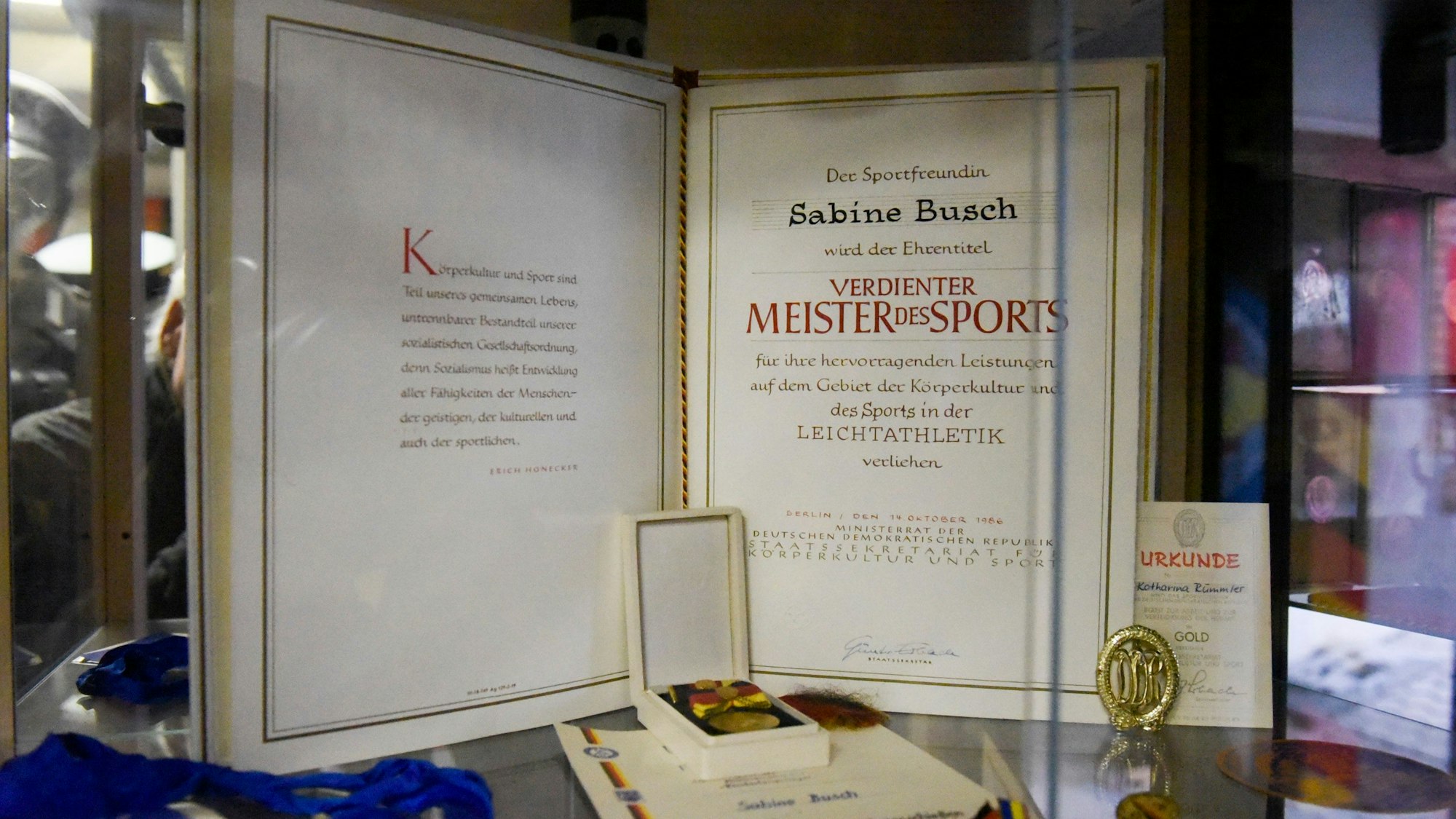 Auf dem Foto sind frühe Siegerurkunden der Leichtathletin Sabine Busch zu sehen.