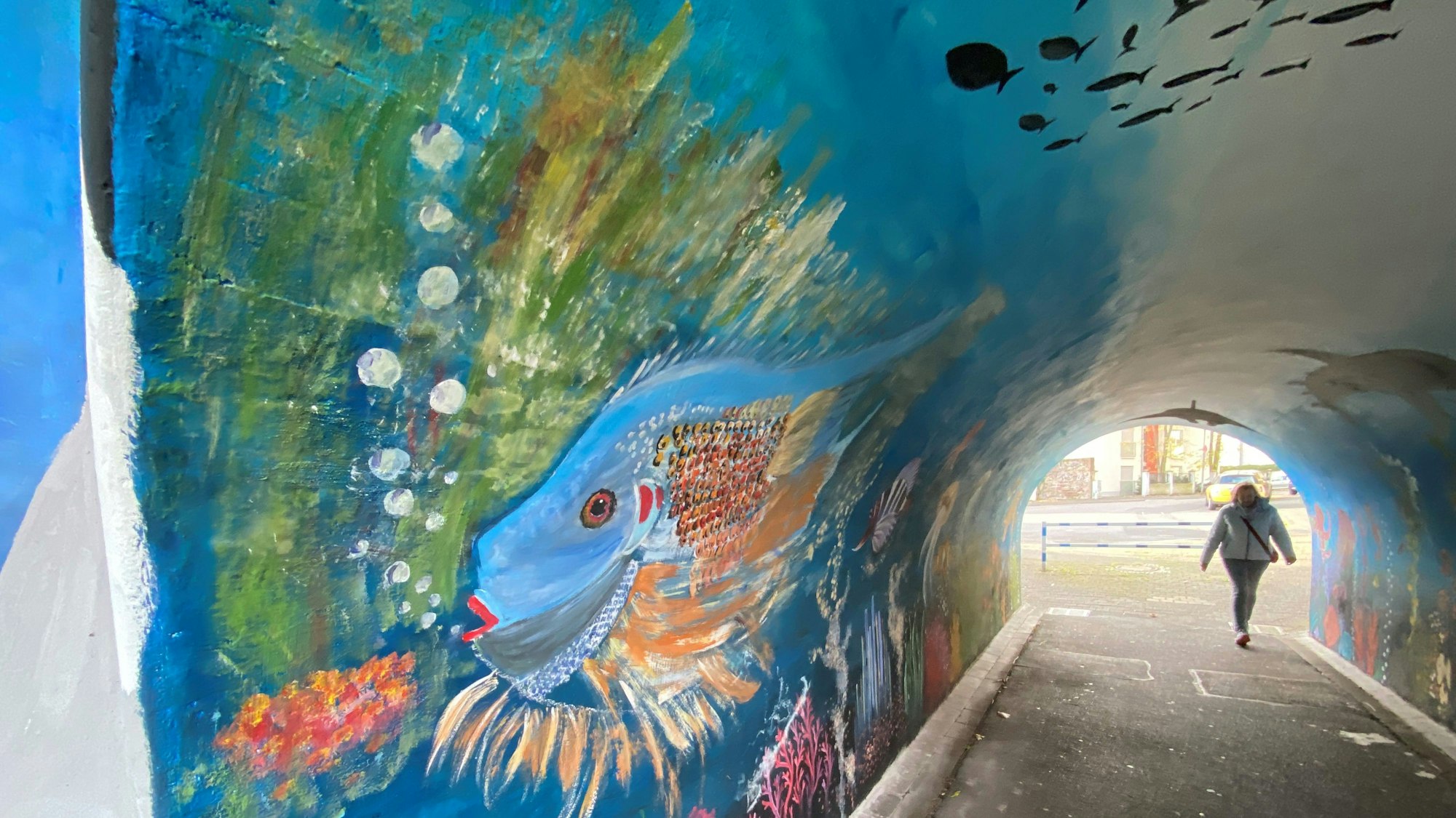 Zu sehen ist die mit einem bunten Fisch bemalte Tunnelwand.