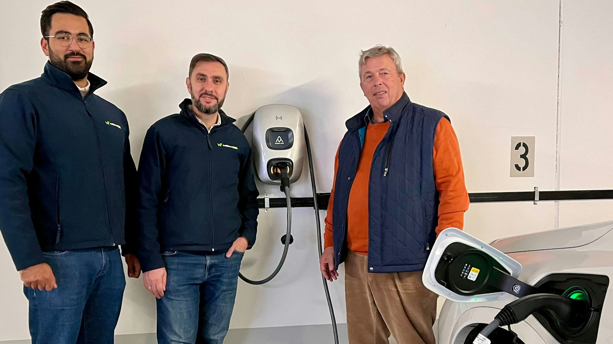 lperen Bilal, Wallbox-Now-Gründer Tahsin Yigit und Ulrich Giesen an einer Stromzapfstelle in der Tiefgarage