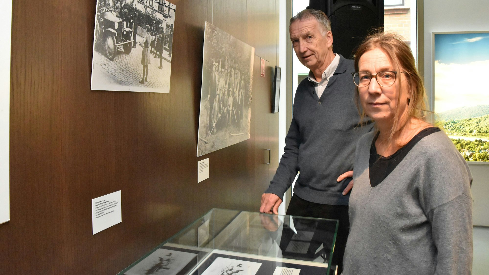 Elmar Scheuren und Dr. Sigrid Lange stehen vor eine Vitrine und einer Wand mit Bildern.
