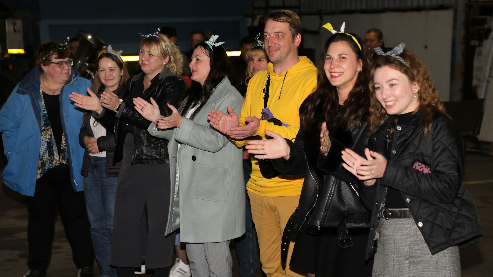 Frauen mit Schleifen in den Haaren empfangen klatschend den Hilfskonvoi aus Bergisch Gladbach.
