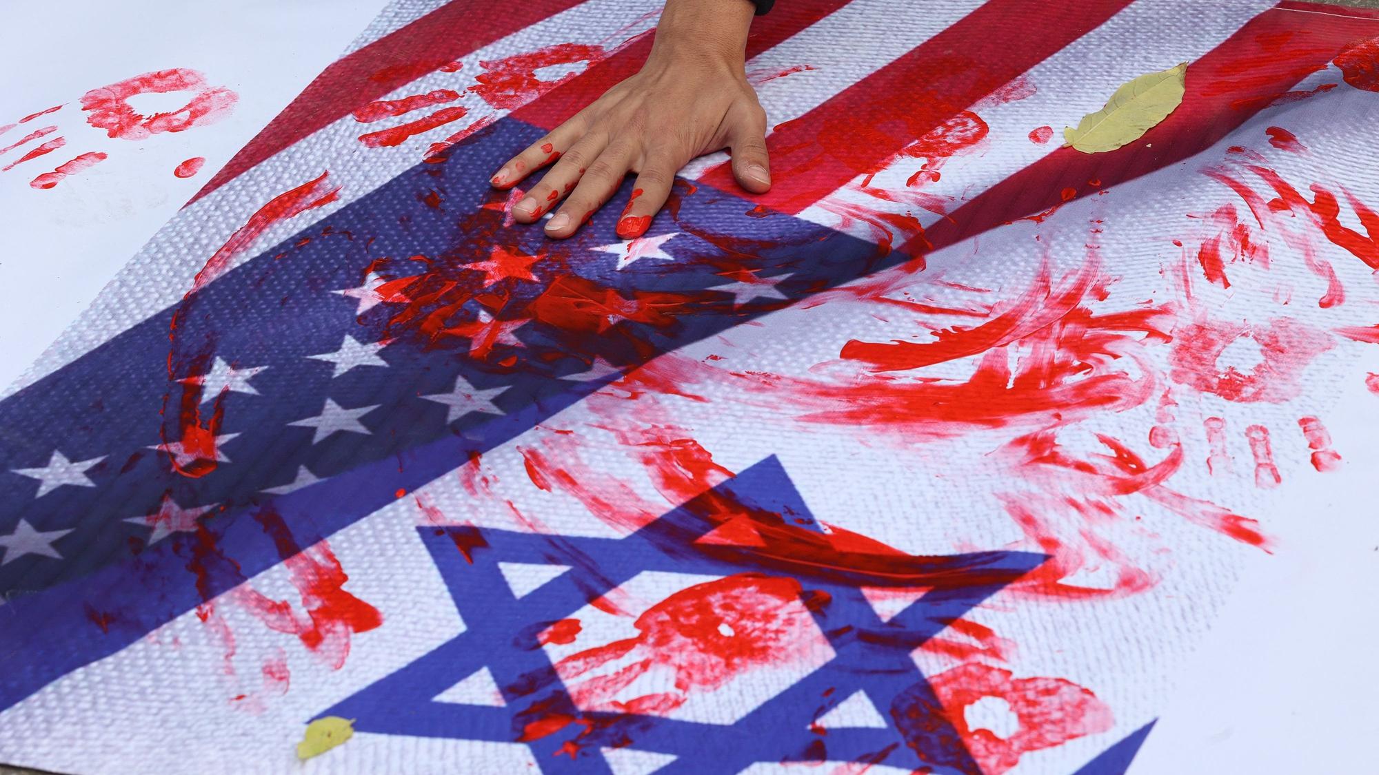 Anakara, Türkei: Ein Mann verteilt rote Farbe auf der israelischen und amerikanischen Flagge. Damit will er gegen den Besuch des US-Außenministers Antony Blinken in Ankara protestieren.