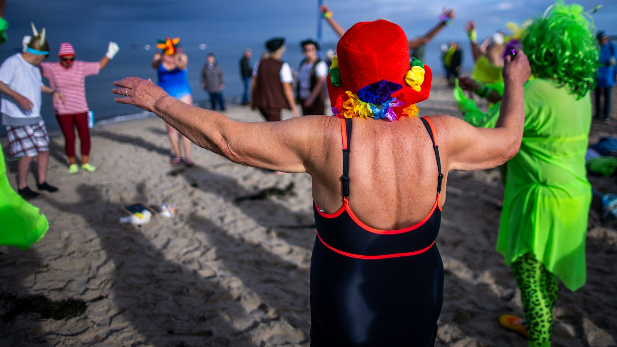 Vor dem kostümierten Eisbaden machen sich die jecken Schimmer gemeinsam warm.