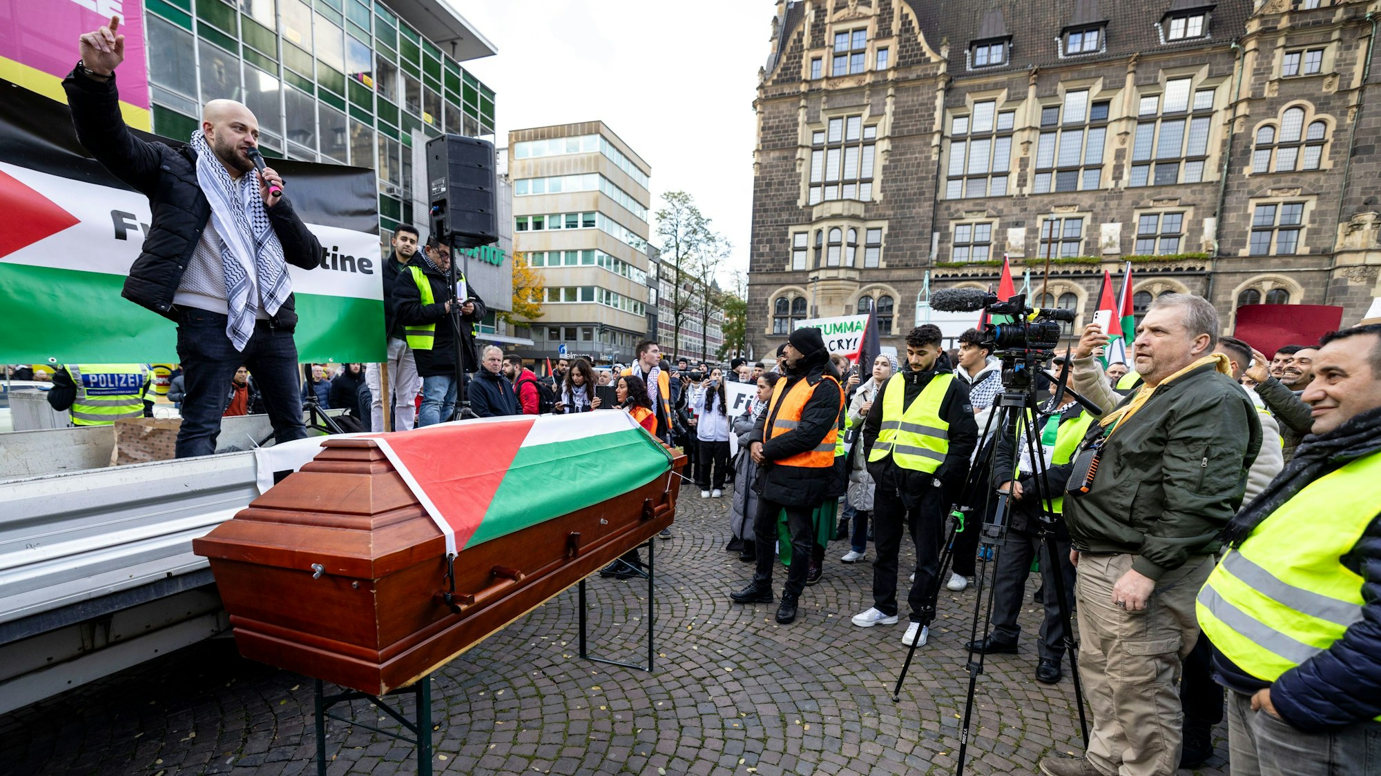 Kundgebung in Wuppertal: Auf der Pro-Palästina-Demo wird ein Sarg mit einer Palästina-Flagge vor der Redner-Bühne gezeigt.