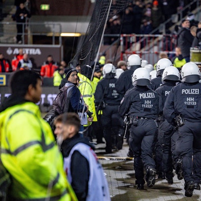 10.11.2023, Hamburg: Fußball: 2. Bundesliga, FC St. Pauli - Hannover 96, 13. Spieltag, Millerntorstadion. Einsatzkräfte der Polizei laufen auf den Fanblock der Hannoveraner zu. Foto: Axel Heimken/dpa - WICHTIGER HINWEIS: Gemäß den Vorgaben der DFL Deutsche Fußball Liga bzw. des DFB Deutscher Fußball-Bund ist es untersagt, in dem Stadion und/oder vom Spiel angefertigte Fotoaufnahmen in Form von Sequenzbildern und/oder videoähnlichen Fotostrecken zu verwerten bzw. verwerten zu lassen. +++ dpa-Bildfunk +++