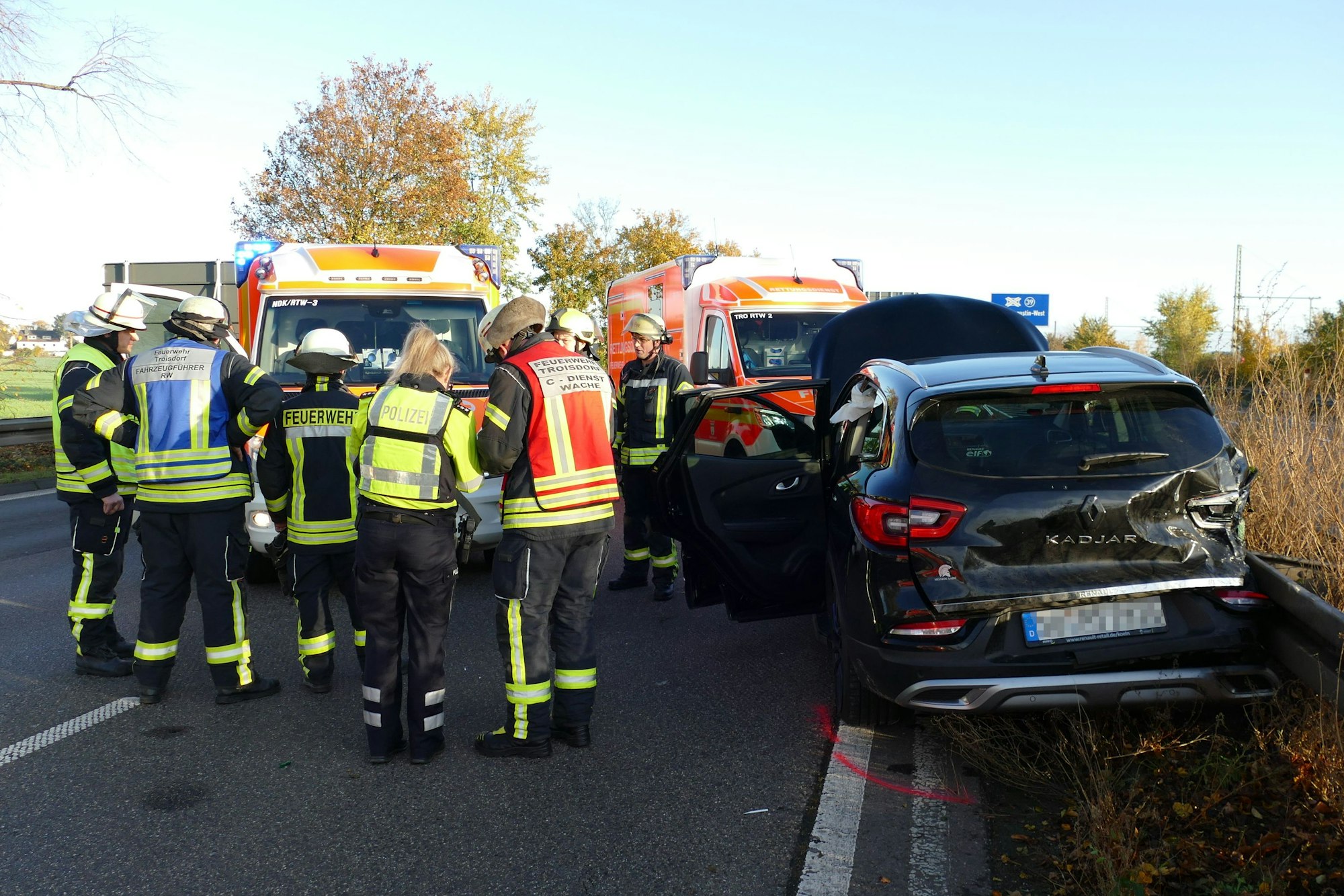 Ein Auto steht entgegen zur Fahrtrichtung auf einer Autobahn, Feuerwehrleute stehen daneben.