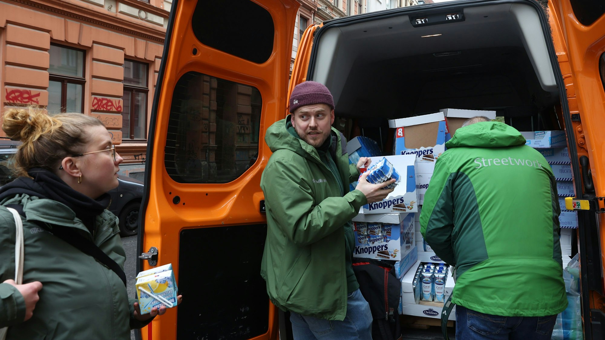 Streetworker Lisa Gindler, Lasse Golob und Uwe Schärpf statten sich mit Snacks und Getränken an ihrem Kleinbus aus.