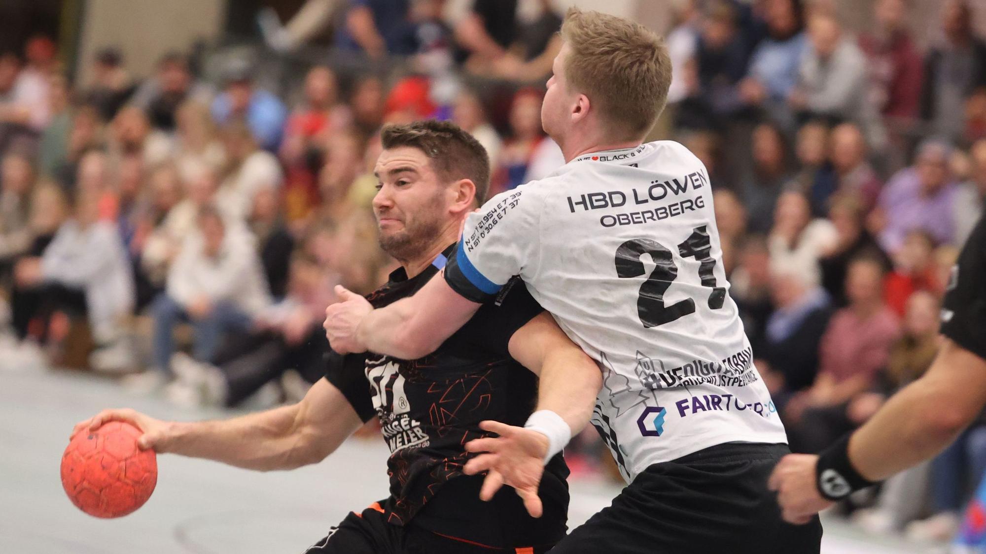 Nümbrechts Tim Hartmann wird mit dem Ball in der Hand von seinem Gegenspieer gestoppt.
