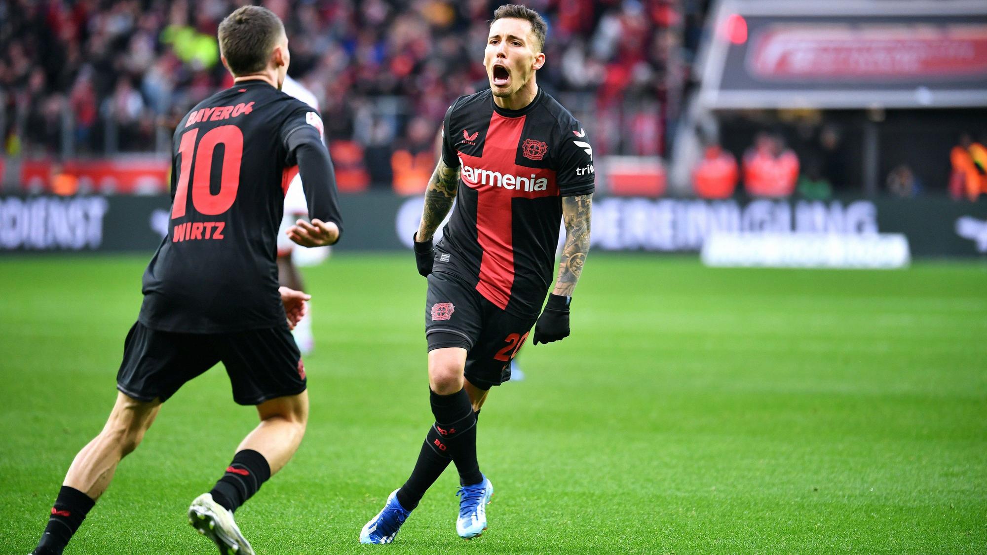 Alejandro Grimaldo feiert nach seinem Tor zum 1:0 mit Florian Wirtz.
