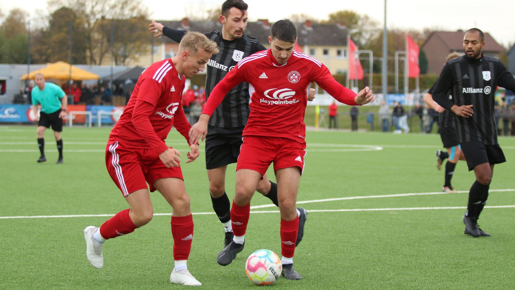 Zülpichs Marius Lepartz hat den Ball und passt ihn zu Nebenmann Manuel Macherey. Von hinten wird Lepartz von einem Gegenspieler bedrängt.