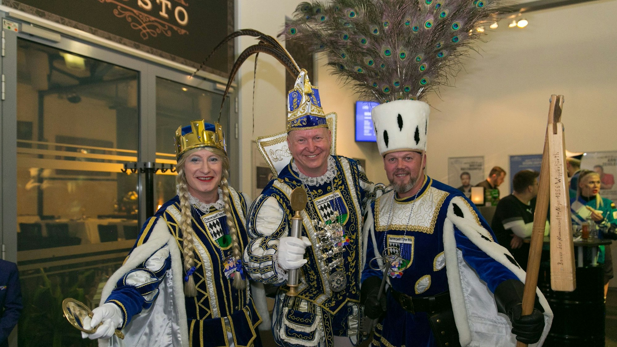Ein Karnevals-Dreigestirn schaut in die Kamera.