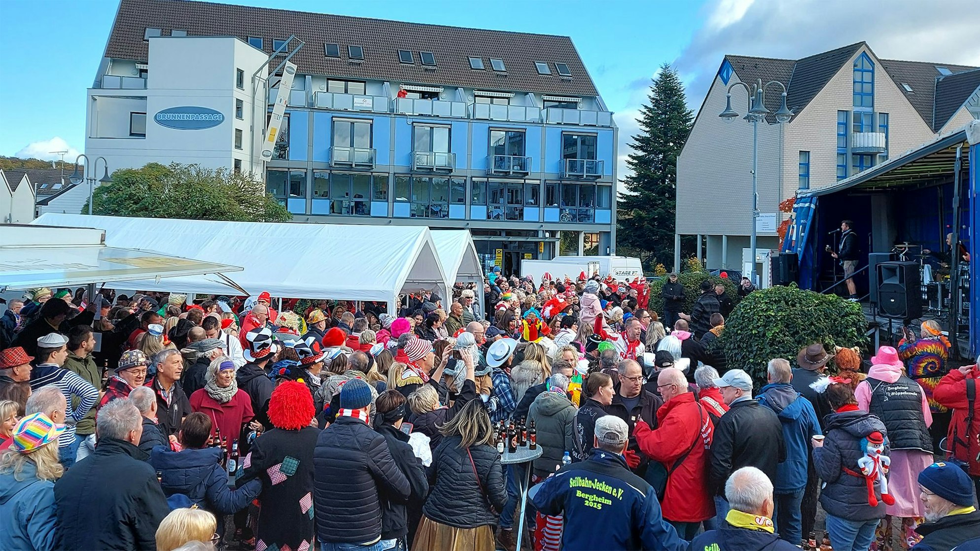 Viele bunt kostümierte Menschen stehen zum Karnevalsauftakt in Mechernich vor einer Bühne.