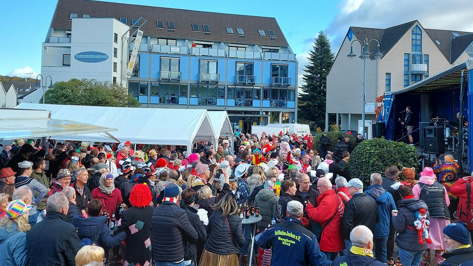 Viele bunt kostümierte Menschen stehen zum Karnevalsauftakt in Mechernich vor einer Bühne.