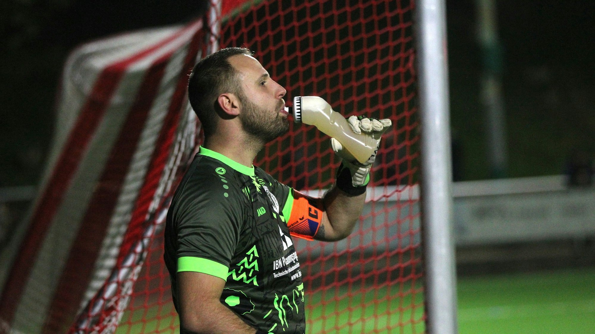 Torwart Dominik Schöpfer trinkt aus einer Flasche.