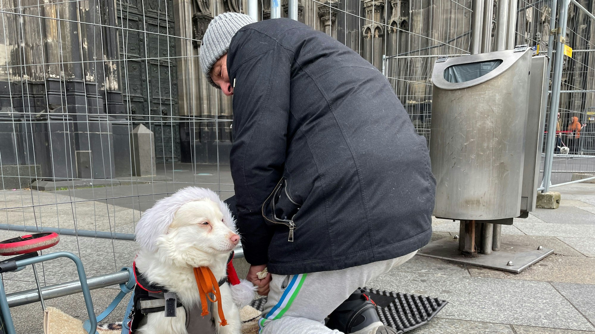 Thomas sitzt mit seinem Hund vor dem Dom.