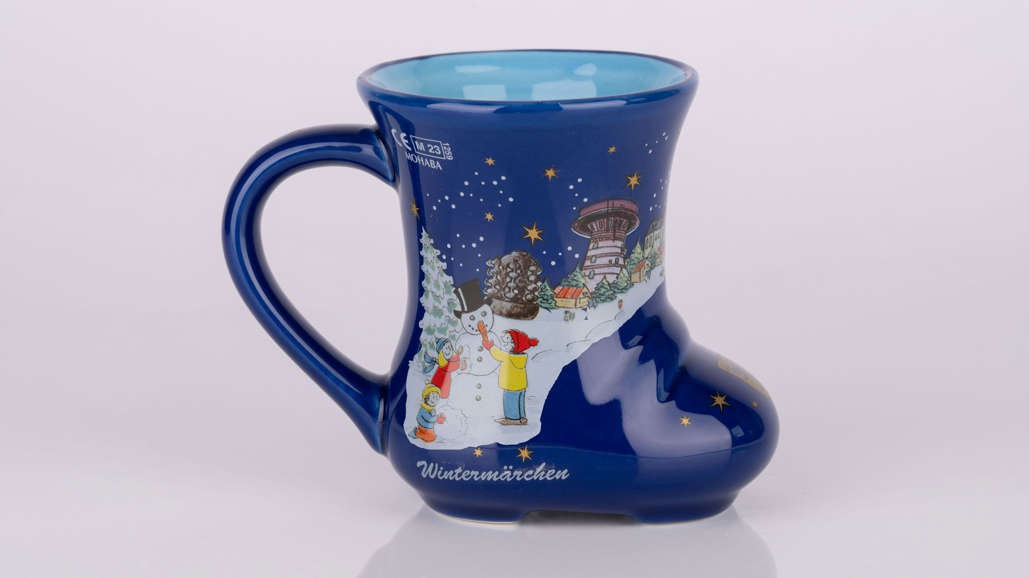 Eine blaue Tasse in Form eines Stiefels mit Frechener Motiven.