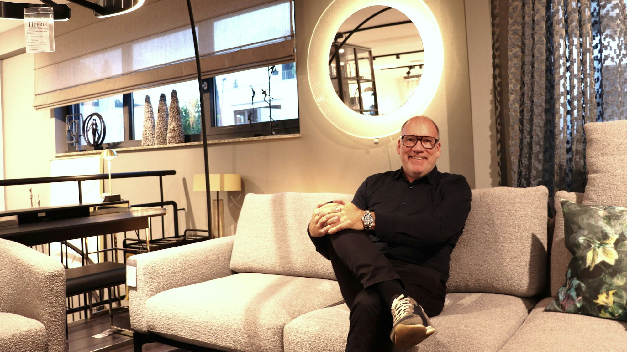 Der Eigentümer Peter Heerdt sitzt auf einer Couch in seinem Laden am Bonner Wall.