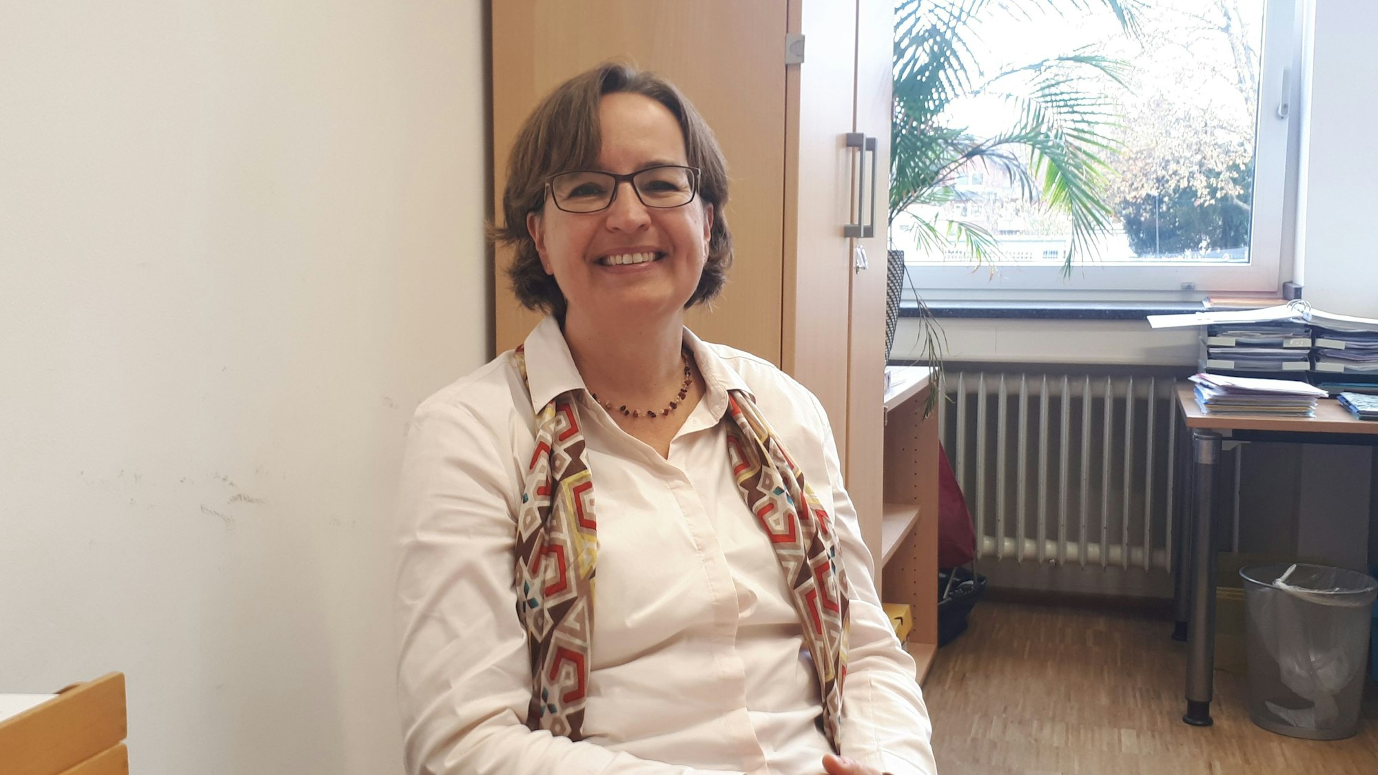 Eine Schulleiterin sitzt in ihrem Büro.